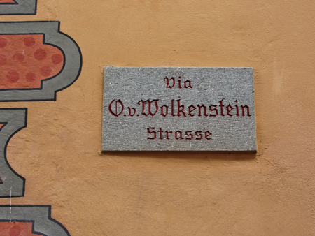 Signboard with name of the street in the center of Castelrotto (Kastelruth) - the town is a gateway to the Alpe di Siusi, the largest high Alpine meadow in Europe, and the rugged Dolomites mountainsの写真素材