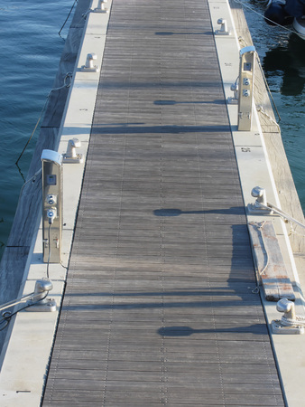 Wooden pier for boats with electricity supply appliances in the harbor in Marina di Pisa, Tuscany,...