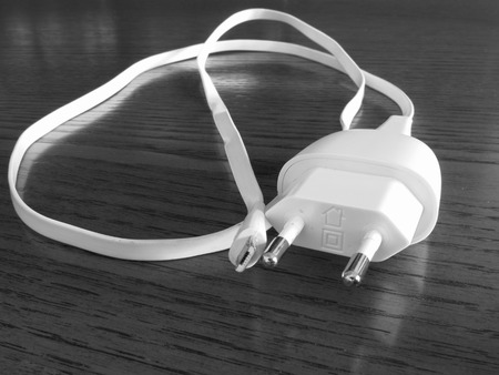 White smartphone charger on wooden table . Black and white photoの写真素材