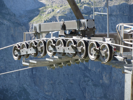 Cable car gear wheels with mountains background . Rollers and pulleys of the ski liftの写真素材