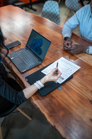 High angle view of business people discussing over document at table in office