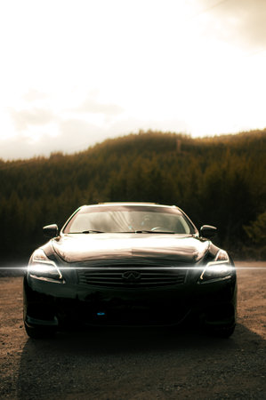Front view of a black sports car on the road in the mountainsの写真素材