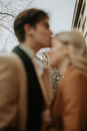 Young couple kissing in the street, focus on the man's faceの写真素材