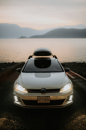 White Porsche Cayenne Coupe on the beach at sunset.のeditorial素材