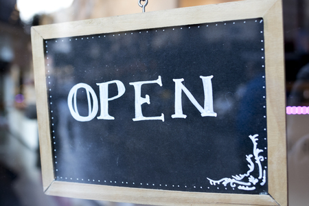 Open word written on a small blackboard.