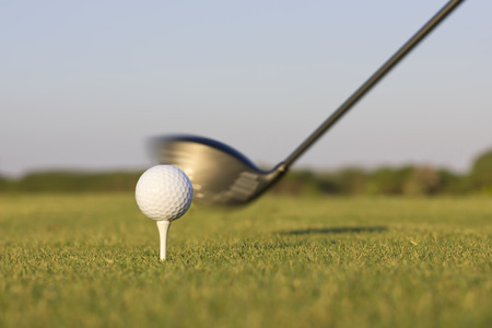 Closeup image of a golf club about to hit a golf ball.の写真素材