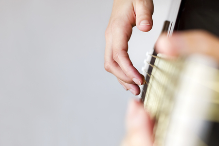 Closeup image of the right hand playing the guitar strings.の写真素材