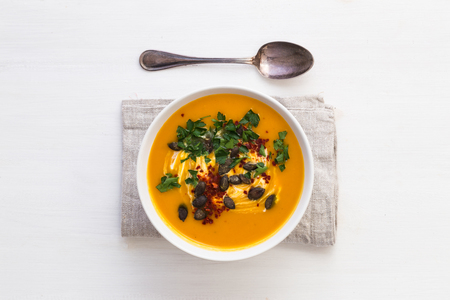 Butternut squash soup with napkin and spoonの写真素材