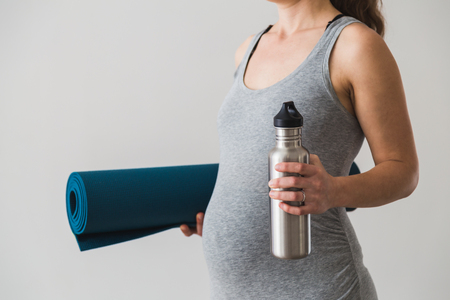 Young woman in early pregnancy going to an exercise classの写真素材