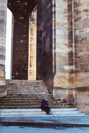 Bordeaux, France - Old man sat on steps of Fleche Saint Michel, part of Basilique Saint Michel.のeditorial素材