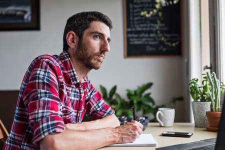 Male entrepreneur thinking about new business solutions in home officeの写真素材