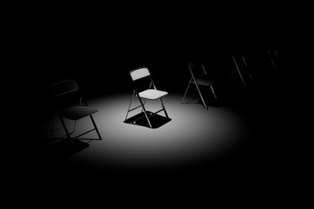 psychological assistance. chairs with a dark room one of which is illuminated by the beam of a spotlight. 3D rendering.の写真素材