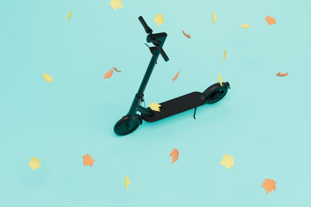 movement on an electric scooter. an electric scooter around which leaves scatter on a blue background. 3D rendering.の写真素材