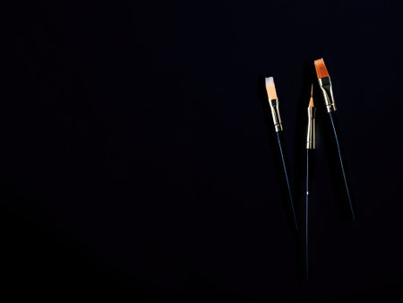 a group of paintbrushes on black background. copy paste, copy space. ai generative.の素材