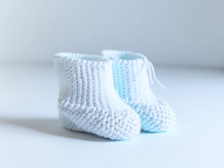 Handmade knitted baby booties on white background. ai generative.の素材