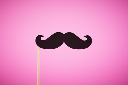 mustache on a stick isolated on pink background. ai generative.の写真素材