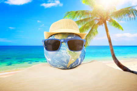 Summer Vacation Concept. Abstract image of planet earth globe laying relax on sand beach. 3d rendering.の写真素材