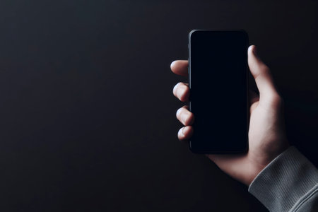 Hand holding mobile phone. Minimalist black background Mockup, ai generative.の素材