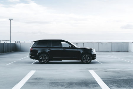 Black and white SUV parked in lot, used for vehicle sales, rentals, or auto insurance visuals in a commercial setting.の素材