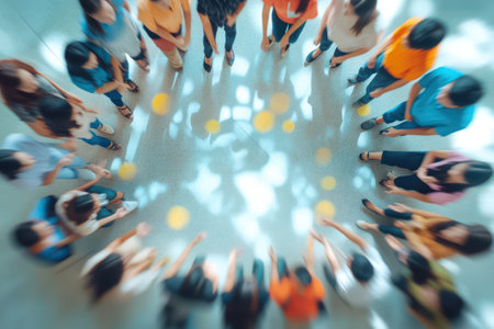 Defocused top view of team sitting in circle during workplace discussion, ideal for abstract concepts of collaboration and teamwork.の素材