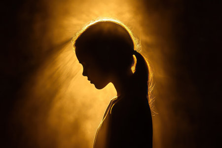 Silhouette of a woman praying earnestly at sunset glow, representing faith, hope, spiritual devotion, and connection with divine power.の素材
