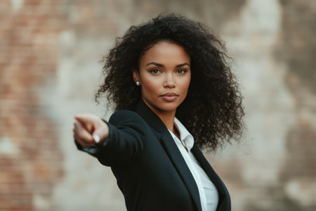 Confident businesswoman gesturing toward team direction, symbolizing vision, teamwork and success in business leadership.の素材