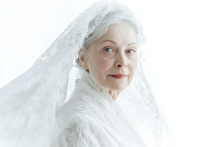 Graceful old woman in a white wedding dress and veil, symbolizing timeless beauty, elegance, and celebration.の素材