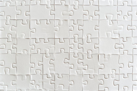 Close-up full frame view of connected white puzzle pieces forming a blank pattern, symbolizing unity, problem solving, and collaboration.の素材