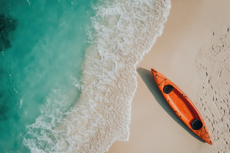 Yellow kayak lies on white sand beach with soft waves, evoking themes of summer, exploration, and peaceful coastal adventure.の素材
