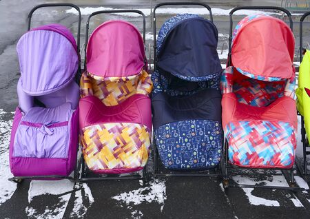  A number of warm-coated children's metal sledges stand on the platform as samples for sale.        ...