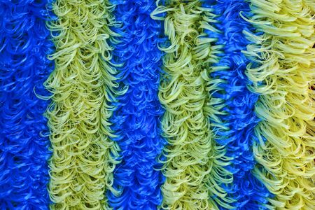 The washcloth is made of thin polymeric material and painted in yellow and blue.の写真素材