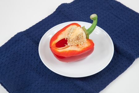 Half cut  red pepper isolated on dark blue and  whiteの写真素材