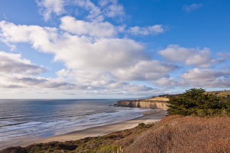 Ocean coastline landscape.  Scenic view of waves breading on rocky ocean coastline under blue skies. の写真素材