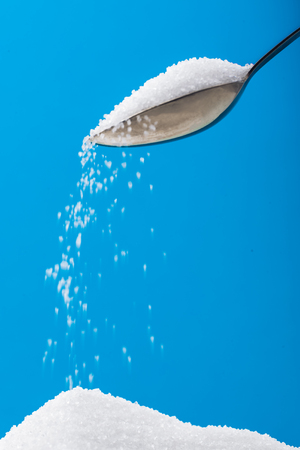 Pouring sugar on a pile of sugarの写真素材