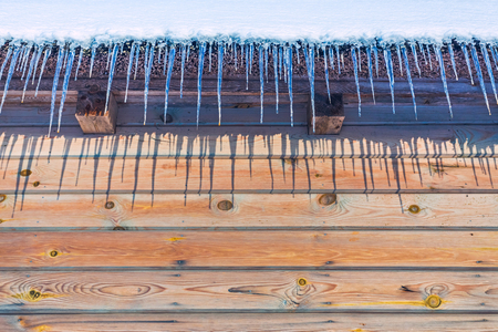 Icicles on vintage roof closeup at winterの写真素材