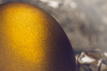 Image of shiny golden egg on silver foilの写真素材