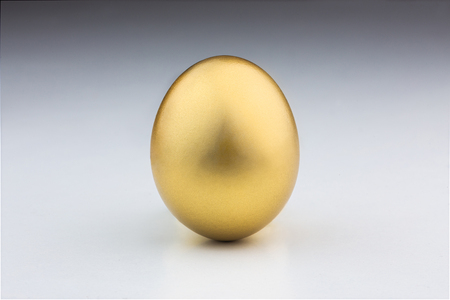 Golden egg isolated in a white backgroundの写真素材