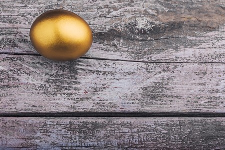 Background of Golden egg on a wooden surface