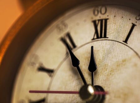 Golden vintage alarm clock showing five to twelveの写真素材
