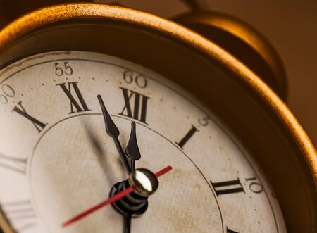 Golden vintage alarm clock showing five to twelveの写真素材