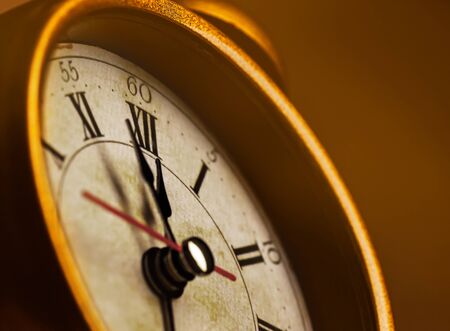 Golden vintage alarm clock showing five to twelveの写真素材