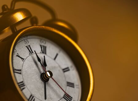Golden vintage alarm clock showing five to twelveの写真素材