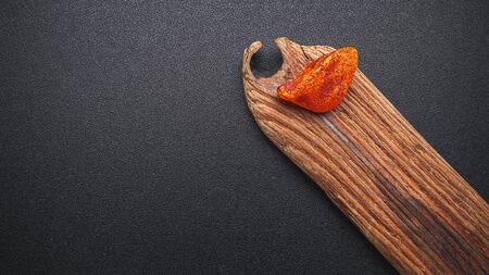 Natural amber. A piece of yellow transparent natural amber on a piece of textured woodの写真素材