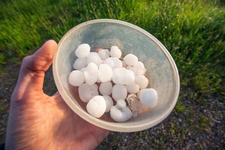 Man holding hailstones after the supercell storm