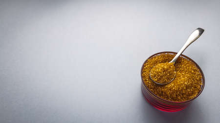 Brown sugar with bowl and spoon on background for textの写真素材