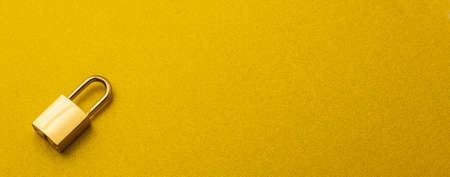 Golden lock on a golden background with empty space for textの写真素材