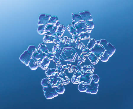 Snowflake on smooth gradient background. Macro photo of real snow crystal on glass surface. This is...