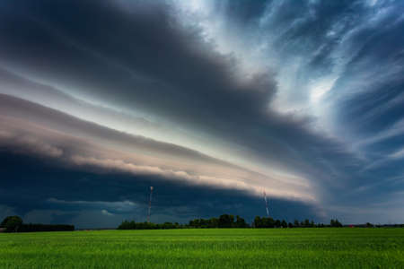Extreme thunderstorm shelf cloud moving over fields, climate change conceptの写真素材