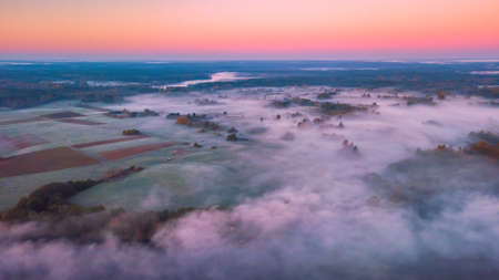 Aerial view of morning fog over the fields at Autumnの写真素材