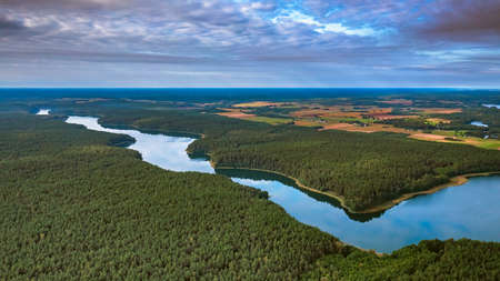 Aerial view of Ancia lake in Lithuania, shiny reflection of sky with clouds in the water of the lakeの写真素材